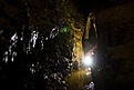Squeezing through a tight passage in Garner Cave, Utah.
